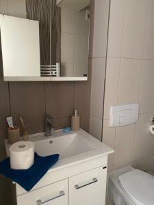 bagno con lavandino, servizi igienici e specchio di CocoLux a Loznica