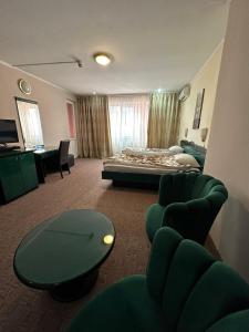 ブカレストにあるDarin Hotelのベッド、テーブル、椅子が備わるホテルルームです。