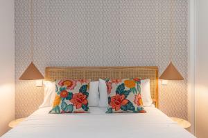 um quarto com uma cama com almofadas florais em BNBHolder Best III Madrid Rio em Madri