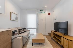 a living room with a couch and a flat screen tv at BNBHolder Best III Madrid Rio in Madrid