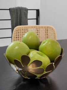 a bowl of green apples sitting on a table at VENUS Central Sydney - FEMALE ONLY HOSTEL in Sydney