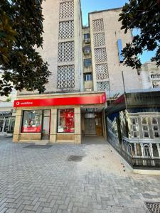 budynek z czerwonym znakiem przed nim w obiekcie Tirana Central Apartments - Premium w Tiranie