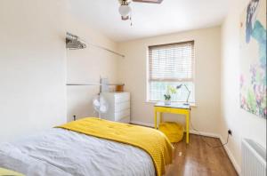 um quarto com uma cama e um cobertor amarelo em Stunning 1 bed flat in the heart of Greenwich em Londres