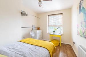 1 dormitorio con cama y manta amarilla en Stunning 1 bed flat in the heart of Greenwich, en Londres