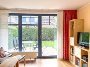 sala de estar con puerta corredera de cristal que da a un patio en Feriendorf Papillon Wohnung 09-4, en Boltenhagen
