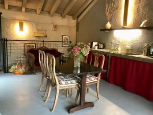 une salle à manger avec une table, des chaises et des fleurs. dans l'établissement Casa 1000fiori, à Faggeto Lario 