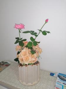 un jarrón lleno de rosas rosas sobre una mesa en Casa Anna, en Cava deʼ Tirreni