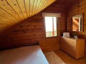 Nemoral Chalet في أراخوفا: غرفة نوم في كابينة خشب بها سرير ونافذة