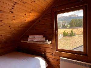 Nemoral Chalet في أراخوفا: غرفة نوم مع نافذة في كابينة خشب