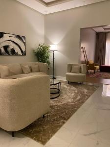 a living room with a couch and two chairs at شقق مودرن مقابلة البوليفارد in Riyadh +181 photos
