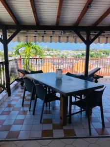 a table and chairs on a patio with a view at Chambre d'hôtes MAÏ TAÏ 4 personnes Bas du Fort in Le Gosier