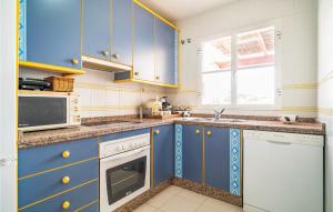 a kitchen with blue cabinets and white appliances at 2 Bedroom Gorgeous Apartment In Málaga in Málaga