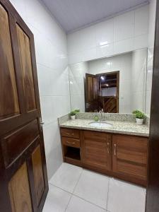 a bathroom with a sink and a mirror at Vila dos pássaros, Quarto 02 in Itapema