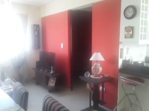 una sala de estar con paredes rojas y una mesa con lámpara. en Mendoza en Mendoza