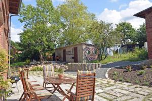 d'une terrasse avec une table et des chaises dans la cour. dans l'établissement schöne Ferienwohnung mit Kamin und Terrasse in Sassnitz H, à Dwasieden