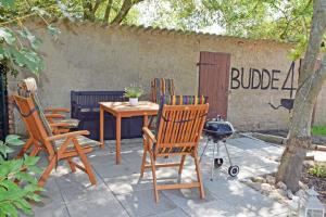 un patio avec des chaises, une table et un grill dans l'établissement schöne Ferienwohnung mit Kamin und Terrasse in Sassnitz H, à Dwasieden