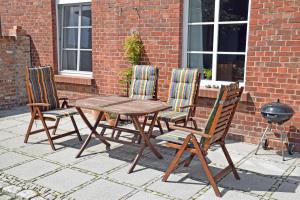 3 chaises et une table en bois ainsi qu'une table et des chaises dans l'établissement schöne Ferienwohnung mit Kamin und Terrasse in Sassnitz H, à Dwasieden