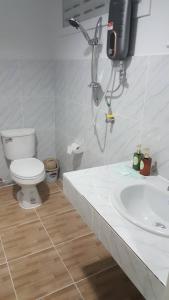 a white bathroom with a toilet and a sink at Lovely Paradise Phangan Hotel in Thongsala