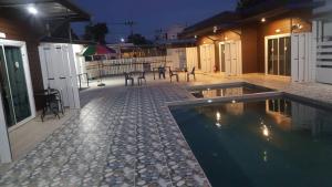 a house with a swimming pool at night at Lovely Paradise Phangan Hotel in Thongsala