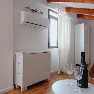 - une cuisine blanche avec une table et deux verres à vin dans l'établissement Terraced paradise, à Alghero