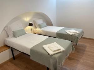 two beds with towels on them in a room at Casa Velha Estremoz in Estremoz