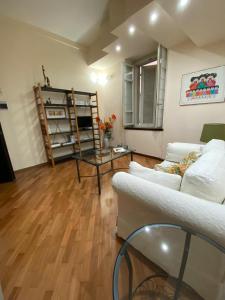 a living room with a white couch and a table at PM 2 Via Scano Guest House A in Sassari