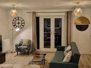 a living room with a green couch and a chair at Modern 2bedroom House in Ipswich Suffolk in Ipswich