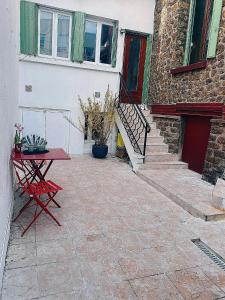 eine Terrasse mit einem Tisch und einem Gebäude in der Unterkunft House Paris 13ème in Ivry-sur-Seine