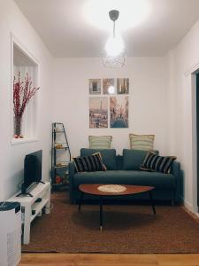 ein Wohnzimmer mit einem grünen Sofa und einem Tisch in der Unterkunft House Paris 13ème in Ivry-sur-Seine