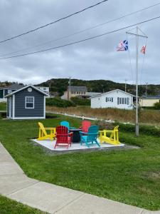 a group of chairs sitting around a table in a yard at Storytellers Retreat in Twillingate
