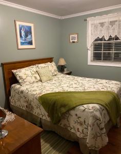a bedroom with a large bed with a green blanket at Storytellers Retreat in Twillingate