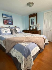 a bedroom with a bed with a blue and white blanket at Storytellers Retreat in Twillingate