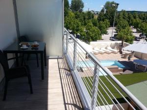 een balkon met een tafel en uitzicht op een zwembad bij Palace Hotel & SPA La CONCHIGLIA D' ORO in Vicenza