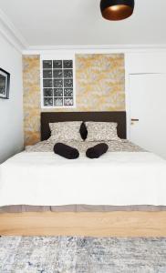 sypialnia z łóżkiem z dwoma czarnymi kapeluszami w obiekcie Luxueux appartement Paris 17 w Paryżu