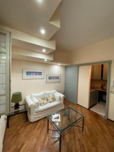 a living room with a white couch and a glass table at PM 2 Via Scano Guest House A in Sassari