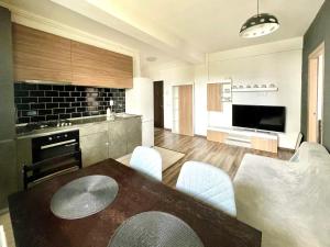 uma cozinha com mesa e cadeiras num quarto em YamaLux Apartments - Cozy Double - WestSide 3 em Floresti