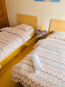 2 Betten in einem Zimmer mit einem lila Tisch in der Unterkunft La Villa des Coteaux - Proche Centre-ville in Lüttich