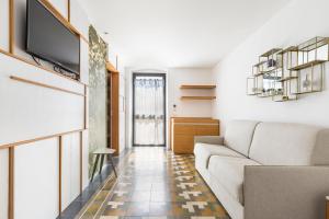 een woonkamer met een bank en een tv bij B&B Palazzo Flora in Collepasso