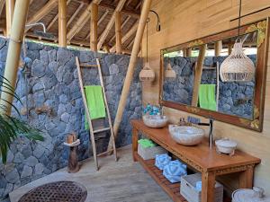 a bathroom with two sinks and a stone wall at Villas Bukit Lipah in Amed +259 photos