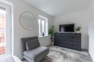 a living room with a chair and a mirror at Stunning 4 Bed 3 Bathroom Home 