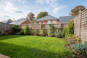 a backyard with a wooden fence and a yard at Stunning 4 Bed 3 Bathroom Home 