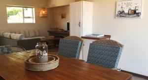 a living room with a wooden table and chairs at Secrets 1 at Waterkant 7 in Jeffreys Bay