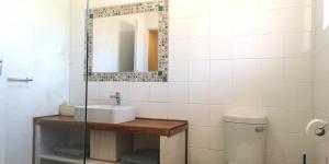 a bathroom with a sink and a mirror and a toilet at Secrets 1 at Waterkant 7 in Jeffreys Bay