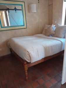 內羅畢的住宿－伍德梅爾服務公寓式酒店，卧室内的一张带白色床单和枕头的床