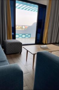 sala de estar con 2 sillas, mesa y ventana en درة العروس غرفة وصالة مع بلكونة مطلة على شاطئ البردايس-عوائل, en Durat Alarous