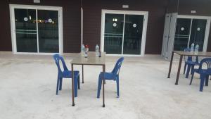 a group of tables and blue chairs in a patio at Lovely Paradise Phangan Hotel in Thong Sala