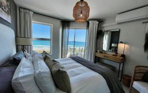 1 dormitorio con 1 cama y vistas al océano en Abode Africa en Bloubergstrand