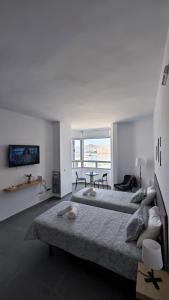 ein weißes Schlafzimmer mit einem großen Bett und einem Tisch in der Unterkunft Chez Frois in Las Palmas de Gran Canaria