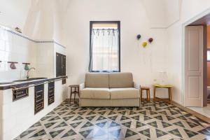 uma sala de estar com uma cadeira e uma cozinha em B&B Palazzo Flora em Collepasso