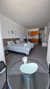 ein Wohnzimmer mit 2 Betten und einem Glastisch in der Unterkunft Chez Frois in Las Palmas de Gran Canaria